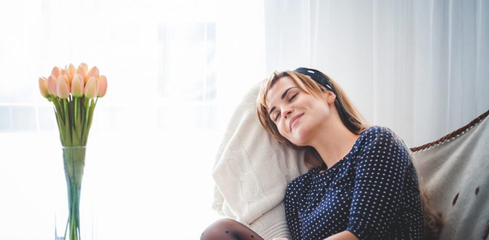 Leisure time at home, young woman relaxing on armchair in bright